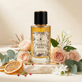 Perfume bottle labeled 'Floral Muse' surrounded by flowers and fruits on a light background